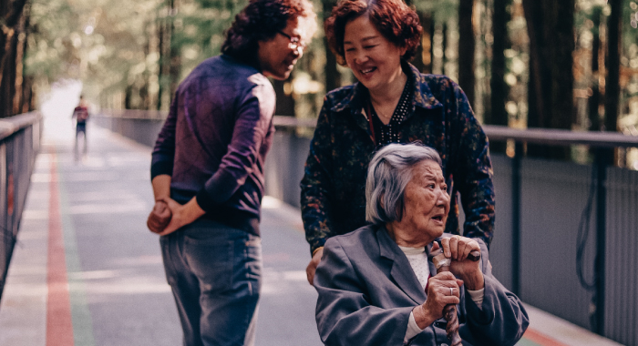 woman pushing an elder lady in a wheelchair 