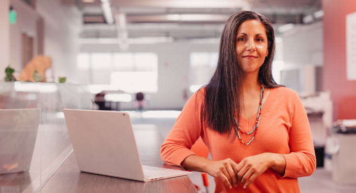 person with a laptop smiling at the camera