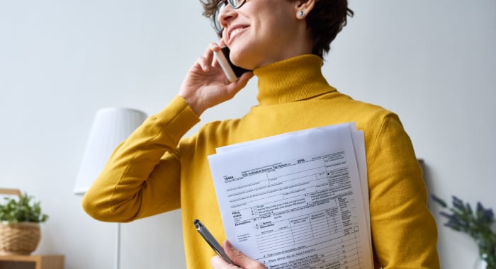 Person on the phone while holding tax documents