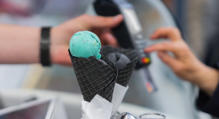 Person paying for an ice cream cone with a credit card