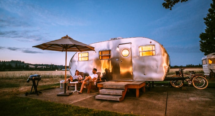 People sitting outside of a camper