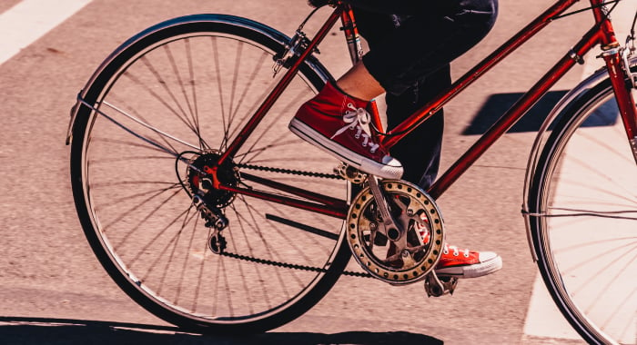 person in red converse shoes pedaling a bike