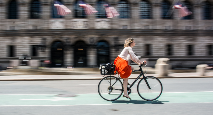 Woman riding a bike in front of the Boston Public Library