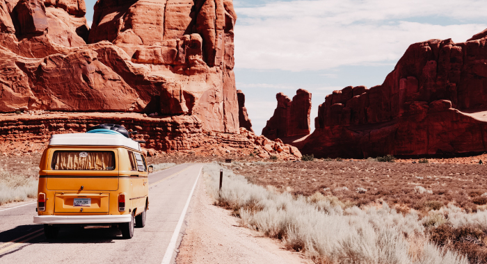 old van driving down a road along a canyon