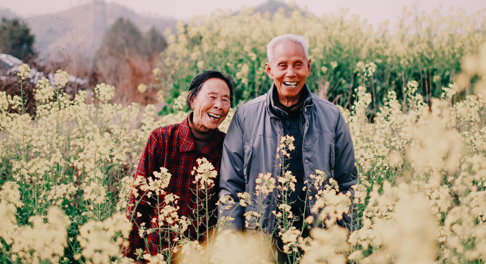 An elderly couple posing in a field