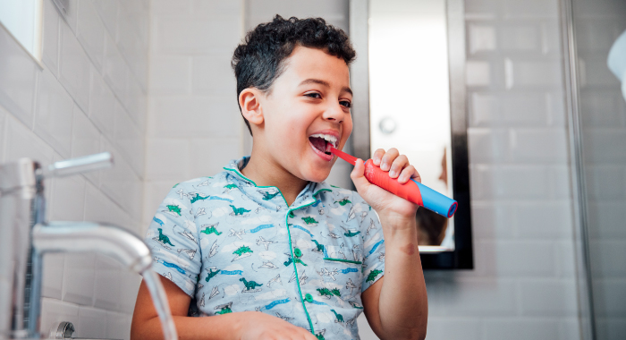 young boy brushing his teeth