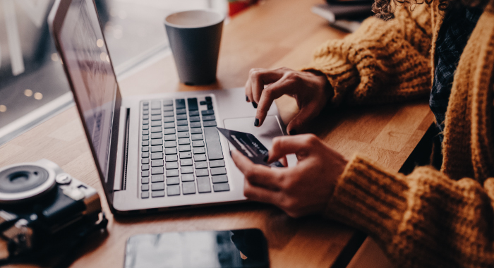 person at a laptop with a credit card out