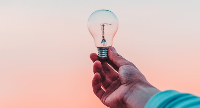 hand holding up a lightbulb 