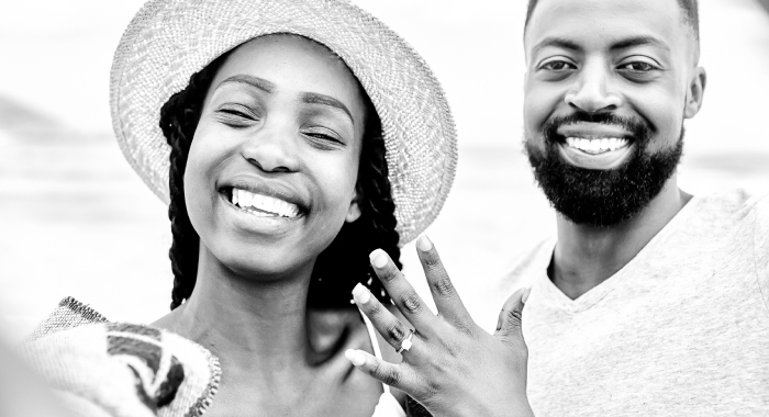 Happy couple showing engagement ring