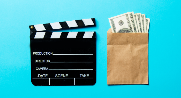 clap board and bag of money on a blue background