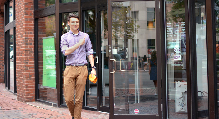 Happy young man in front of HUECU branch