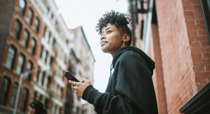 Young woman in the street looking at her smartphone